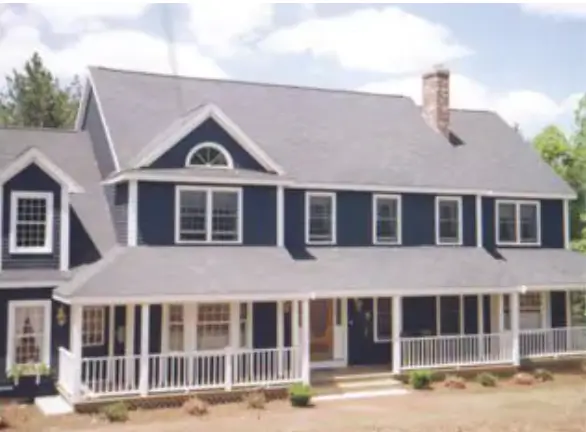 Two-story colonial-style home with dark blue siding, crisp white trim, a covered front porch, and a freshly painted exterior under a bright sky.