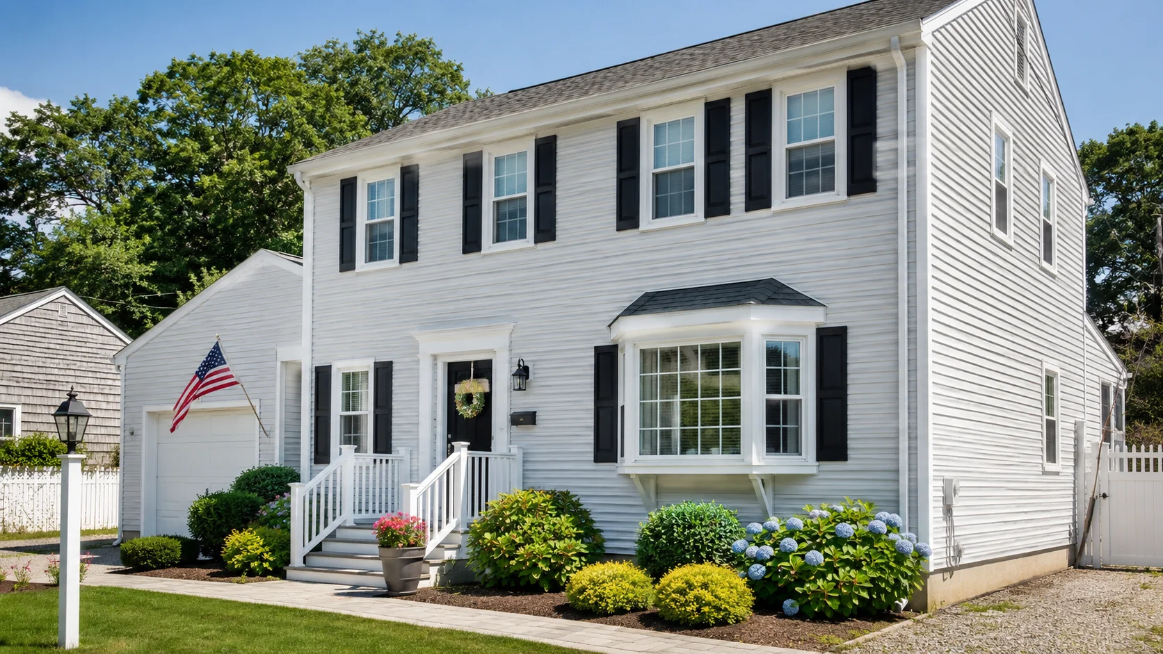 Freshly painted light gray vinyl siding on a well-maintained South Shore home with white trim, black shutters, and updated curb appeal.